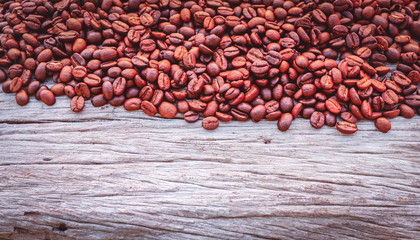 Coffee beans on wooden floor for background. Leave space for adding text.