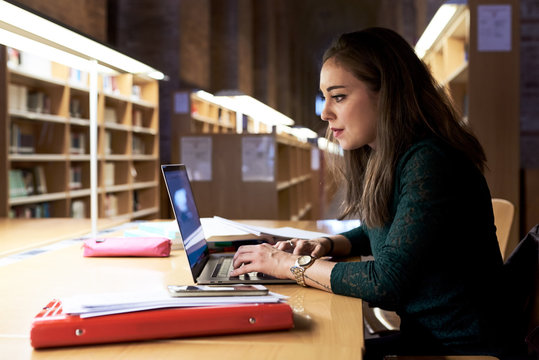 Student using laptop while doing homework
