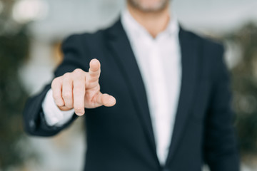 The businessman points his finger at the screen, presses and taps. Blank for the designer to hand.