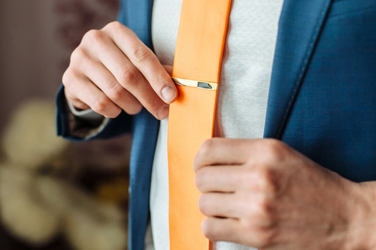 Elegant man straightens tie clip