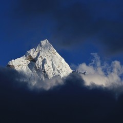 Peak of Mount Ama Dablam surrounded by dark clouds, Everest National Park, Nepal.