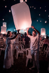 young woman release white lantern in the sky, Chiang Mai Thailand white lantern to release in the sky during Loi Krathong Yee Peng Festival