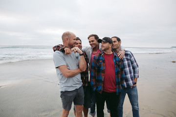 Group of men (brothers) hanging out together on beach