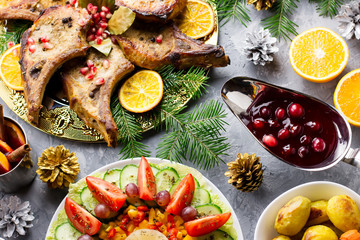 Fototapeta na wymiar Christmas dinner with roasted meat steak, Christmas Wreath salad, baked potato, grilled vegetables, cranberry sauce.