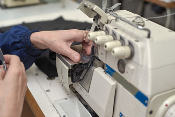 A woman sews on an electric sewing machine.