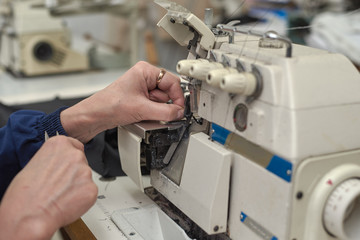 A woman sews on an electric sewing machine.