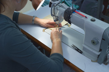A woman sews on an electric sewing machine.