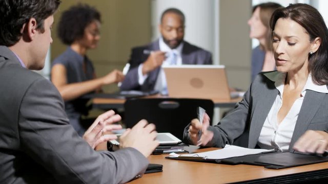 Confident multi ethnic business financial managers discussing investment strategy in clients banking center 