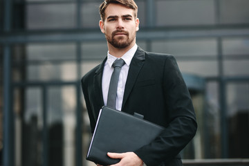 Fototapeta premium Businessman with a folder walking outdoors