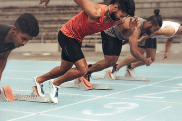 Sprinters taking off for a race on running track