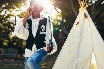 Little boy in pirates costume playing in backyard