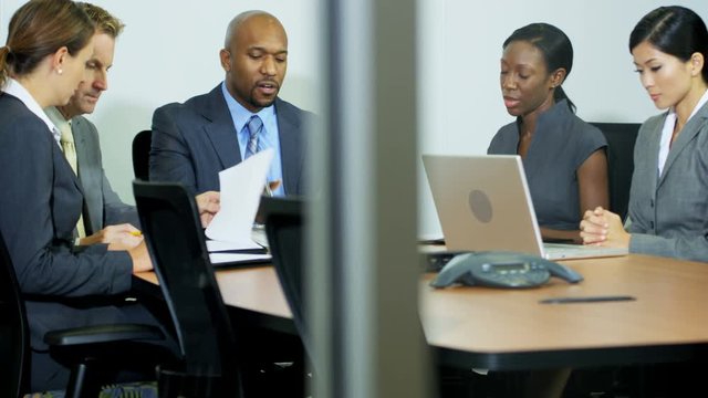 Angry African American businessman scolding his multi ethnic business colleagues in boardroom 