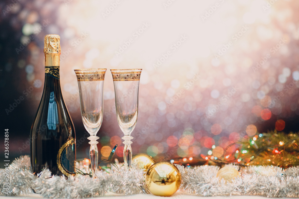 Wall mural new years eve celebration background with champagne and a pair of glasses with christmas decoration.