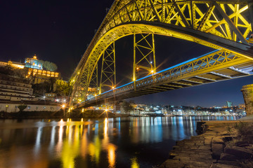 Fototapeta na wymiar dom luise bridge at night with a blu car fast driving porto portugal