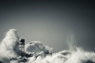 lighthouse with a big wave of water from the ocean with blu sky