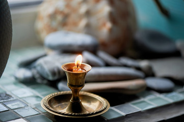 Obraz na płótnie Canvas Burning candle in a copper candlestick. Prayer or gratitude.
