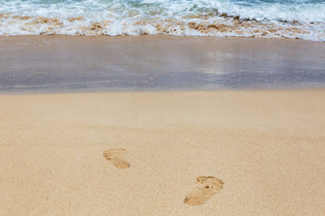 Footsteps at beautiful shoreline at tropical sandy beach in Oahu island, Hawaii