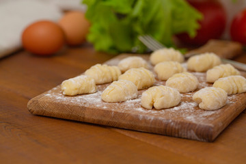 Uncooked homemade gnocchi on cutting board