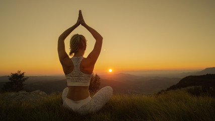 CLOSE UP: Active woman doing yoga in the mountains on a sunny summer evening.