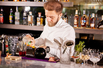 Closeup of bartender hands pouring alcoholic drink.Professional drink making