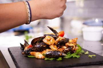 Fine cuisine with seafood on black stone in restaurant kitchen.Delicious food