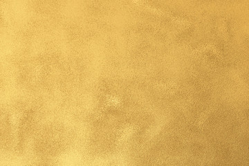 Gold textured surface background with light reflections.