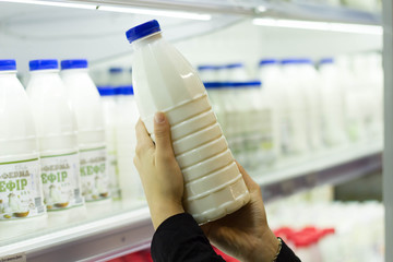female hands holding a bottle of milk