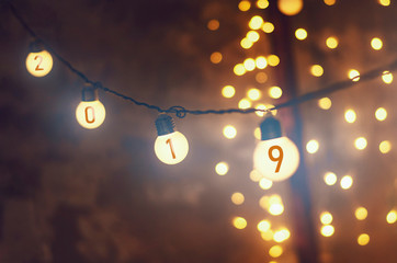 New Year background. garlands and lanterns that hang on a single wire and shine with a soft, warm light creating an evening New Year's Eve atmosphere. An ideal background for wallpapers 