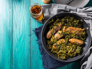 Italian sausages with rapini broccoli in a skillet