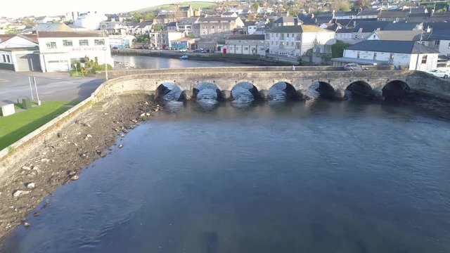 Stunning 4K aerial shot flying over a river in an old Irish town.