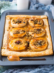 Apple pie on baking tray with caramel and nuts