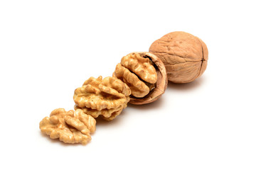 Walnut and kernels, one whole walnut and three kernels in a row, close-up macro, isolated on a white background.