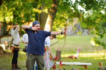 Young male shooting a bow on an annual Medieval Festival, held in Trakai Peninsular Castle.