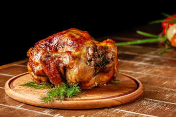 Festive home baked chicken grill for the whole family. chicken lies on a wooden board with sauce and vegetables.
