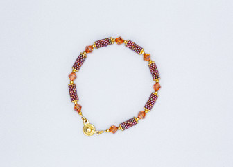 multi colored and variously sized beads bracelet on gray background