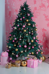 Beautiful decorated Christmas tree and pink boxes with gifts