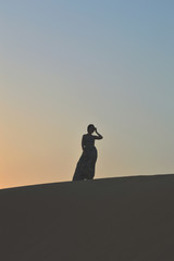 girl in the setting sun in the desert