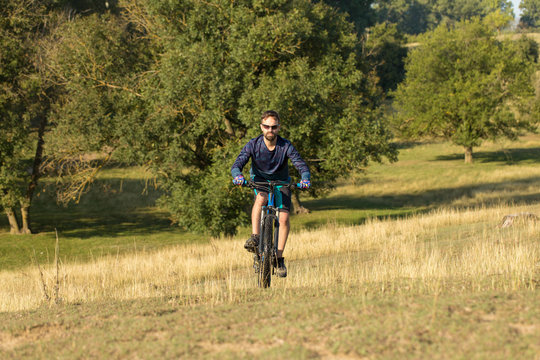 Cyclist in shorts and jersey on a modern carbon hardtail bike with an air suspension fork