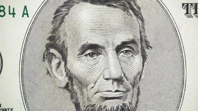 US President Abraham Abe Lincoln portrait on United States 5 dollar bill rotation. 4K UHD video footage