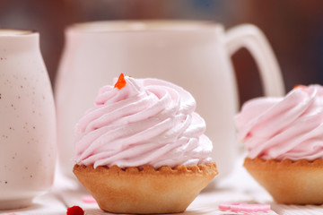 Two cups of coffee and cupcakes with pink cream for Valentine's Day or Birthday, wedding day. White wooden background. Selective focus, close-up