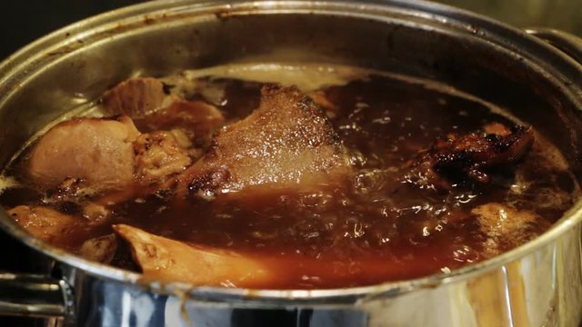 Cooking demi-glace -  rich brown sauce,  French cuisine, used by itself or as a base for other sauces.  Making basic brown stock from beef or veal bones, Closeup.