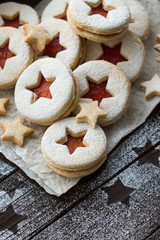 homemade cookies with stars and jam. Linzer biscuits filled with red jam and powdered sugar. Top view. Copy space.