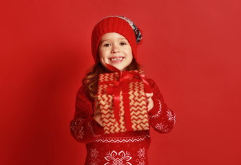happy child girl with christmas gift over red