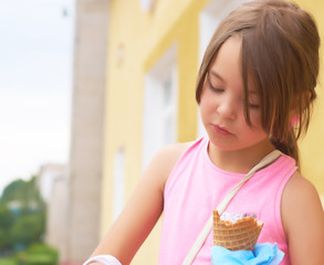Pretty little girl eating licking big ice cream in waffles cone happy laughing on nature background
