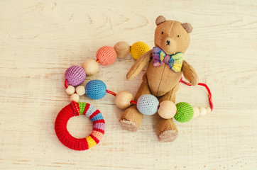 Necklace made from knitted beads and toys for the baby sitting in a sling.