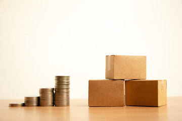 Stack of coins with parcel box on table,growing profit of business concept.