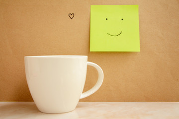 Cup of coffee with smile on paper sticky note.positive thinking. 