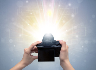 Naked hand taking picture with digital camera and glowing flash concept
