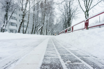Winter frozen pavement walkway under snow in a park. Pavement walkway perspective view abstract winter background