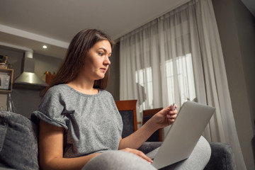 surprised young woman and pregnancy test with laptop, woman looking for information about pregnancy on Internet with laptop